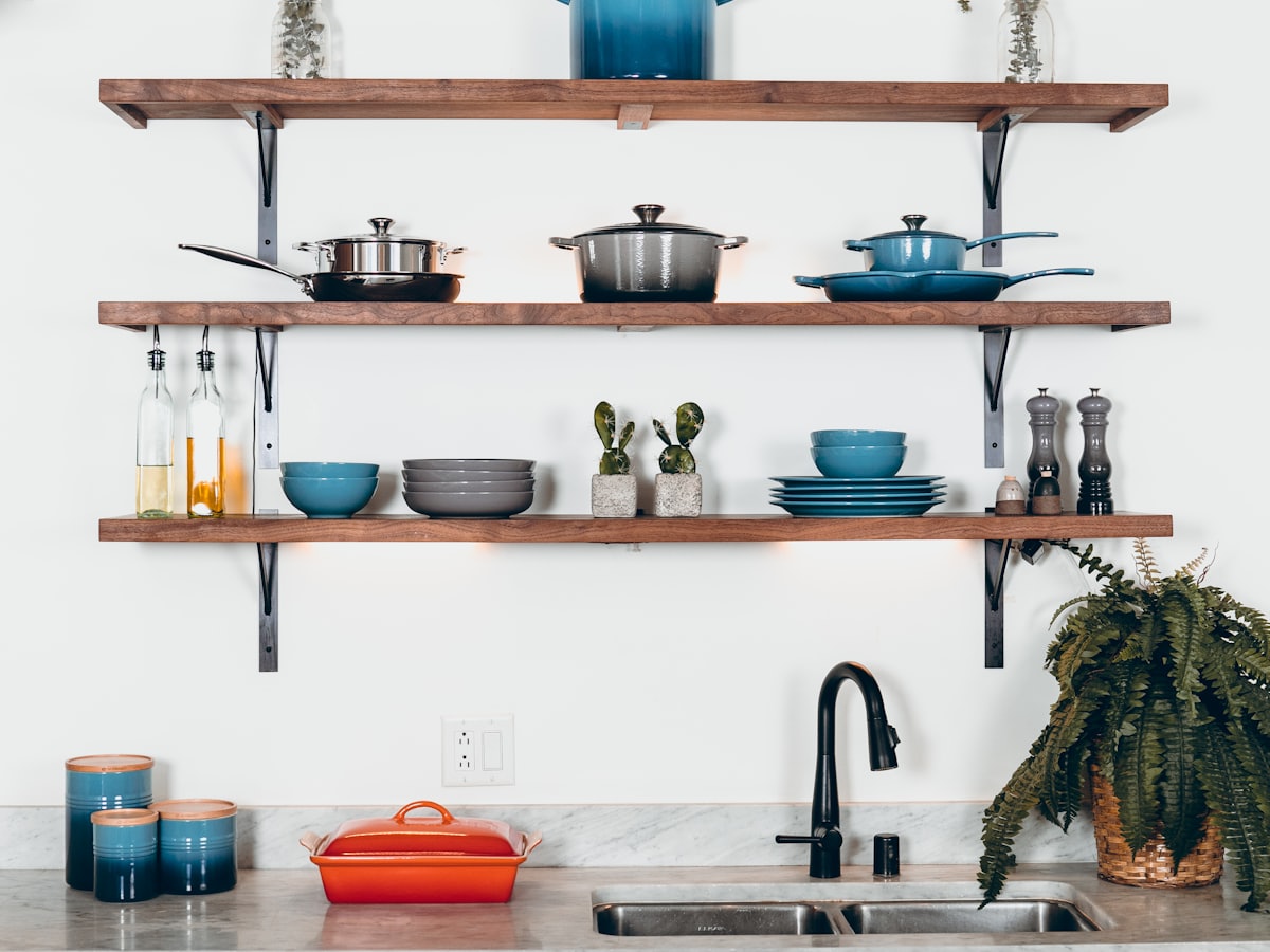 Enameled cast iron cookware on open kitchen shelving